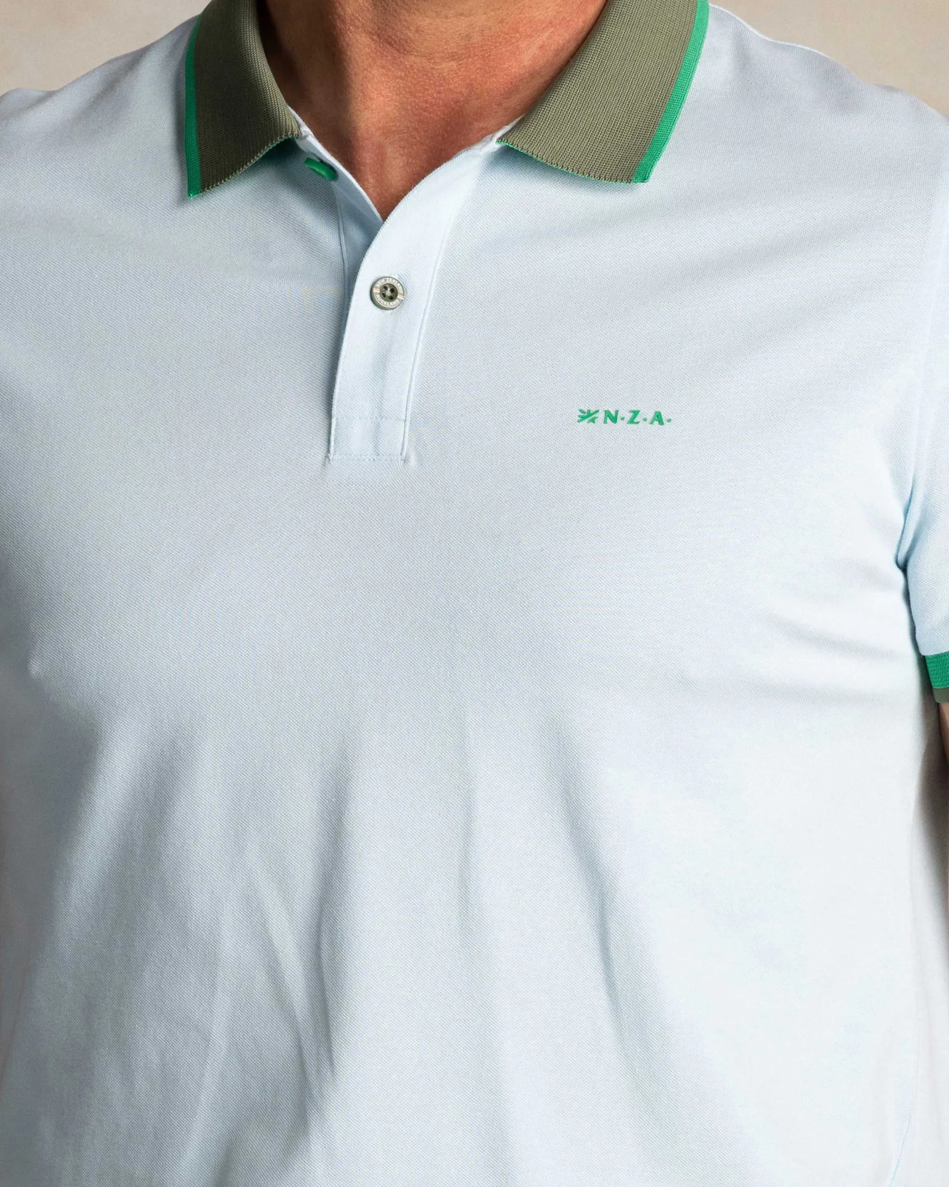 Light blue cotton polo with green collar